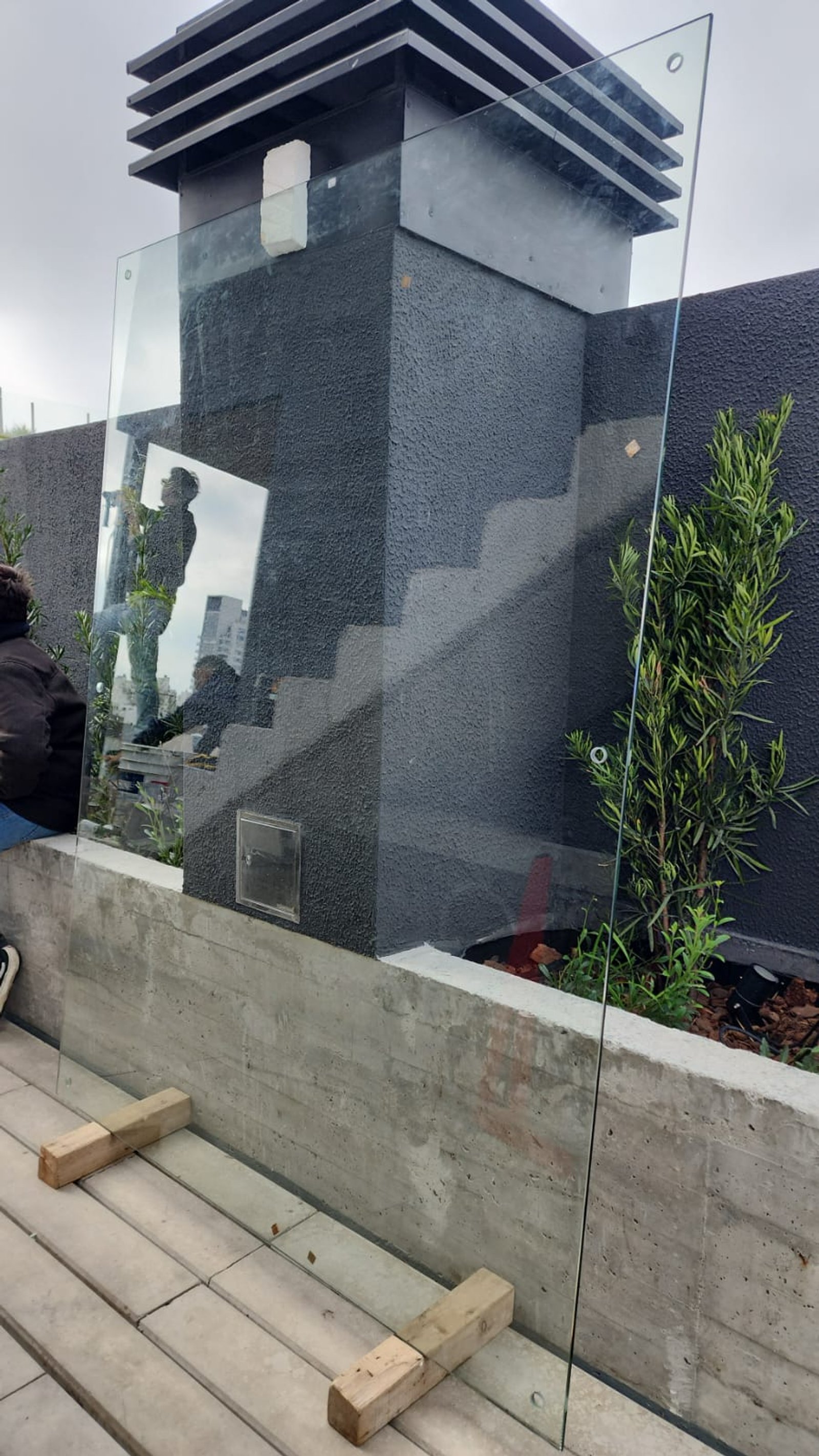 Instalación de panel de vidrio en construcción moderna exterior — proyecto Cortaviento en templado Blindex 10mm incoloro, por Cristalcenter, en Palermo Soho